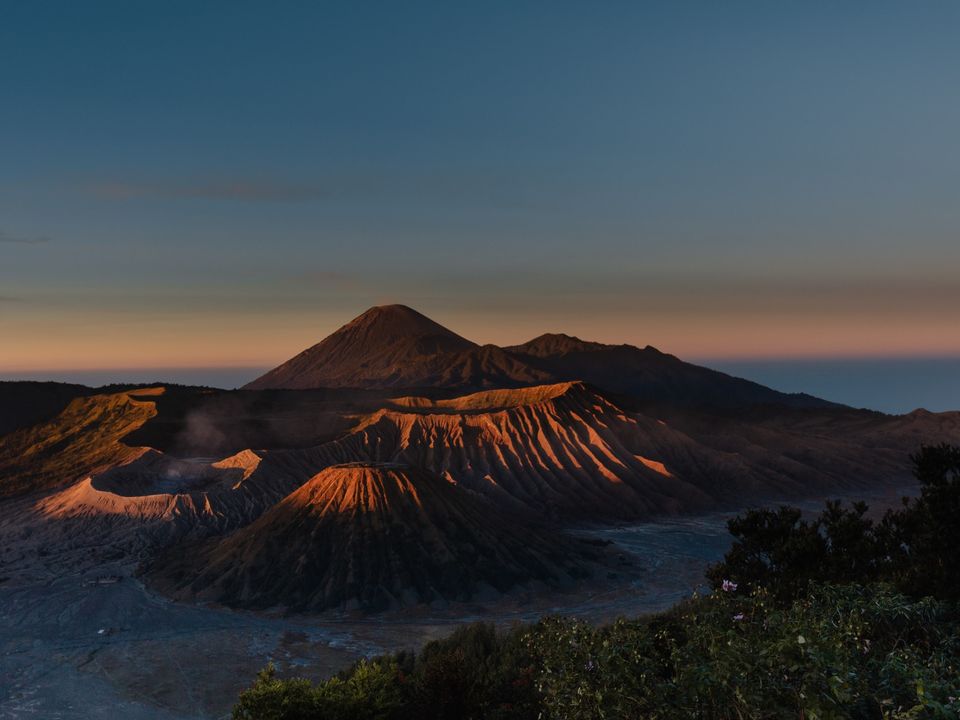 Langzaam wordt de Bromo-vulkaan verlicht tijdens de zonsopkomst, Java