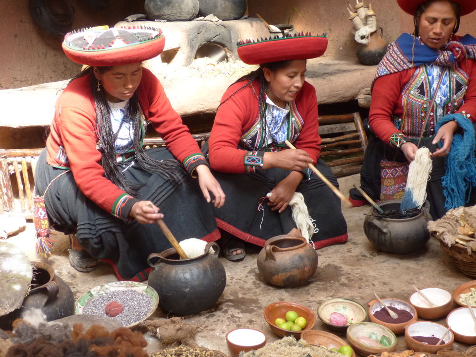 Traditioneel geklede vrouwen kleuren het geweefde wol in Maras, Peru