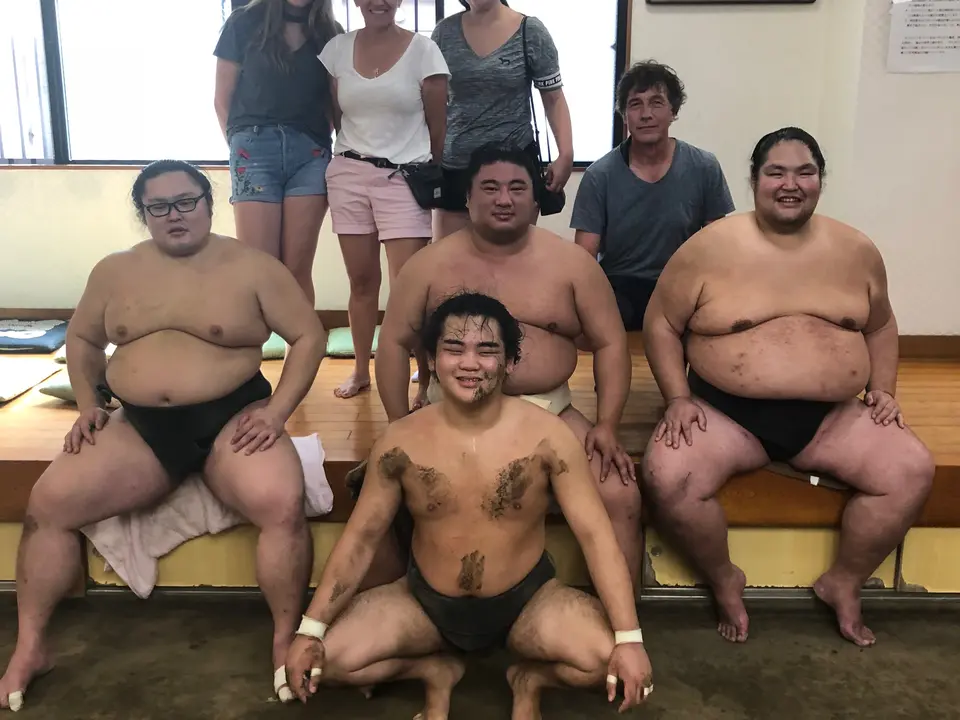 Klanten op de foto met sumo worstelaars in Tokyo