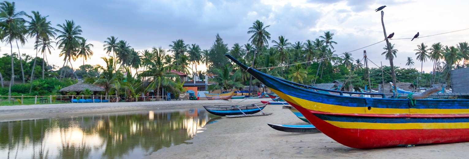 Kleurrijke bootjes bij de kustlijn van Arugam Bay, Sri Lanka
