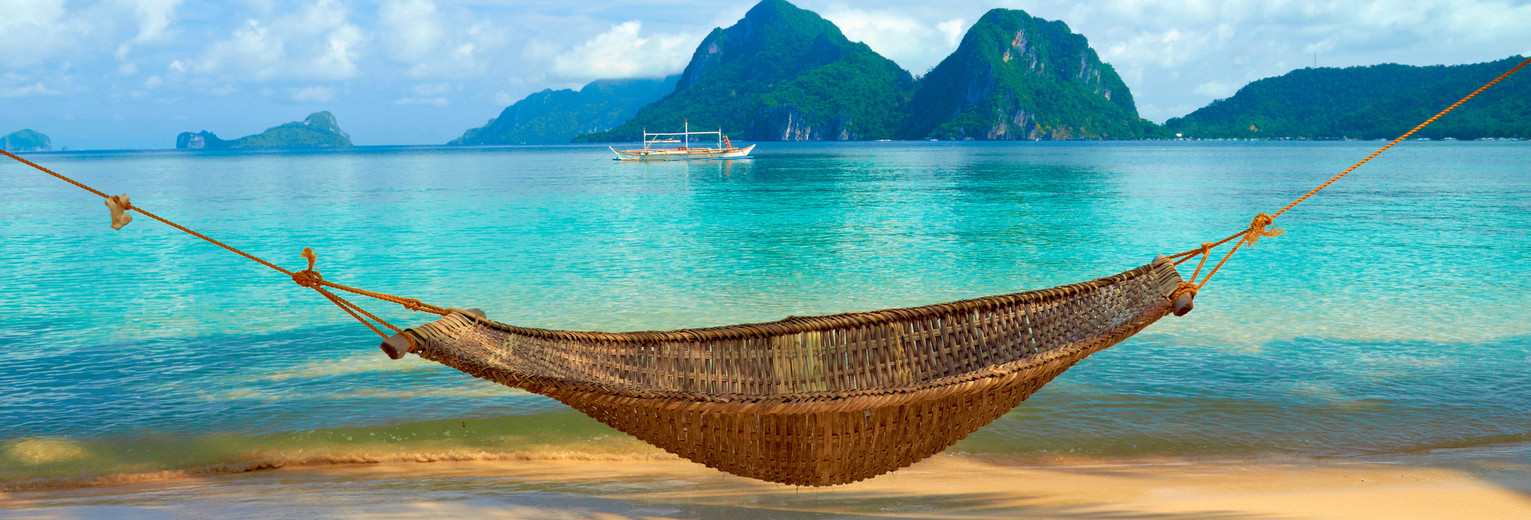 Relaxen in een hangmat op het strand van Krabi in Thailand Relaxen in een hangmat op het strand van Krabi in Thailand
