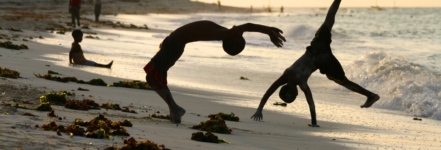 Kinderen genieten van het spelen op het strand op Zanzibar