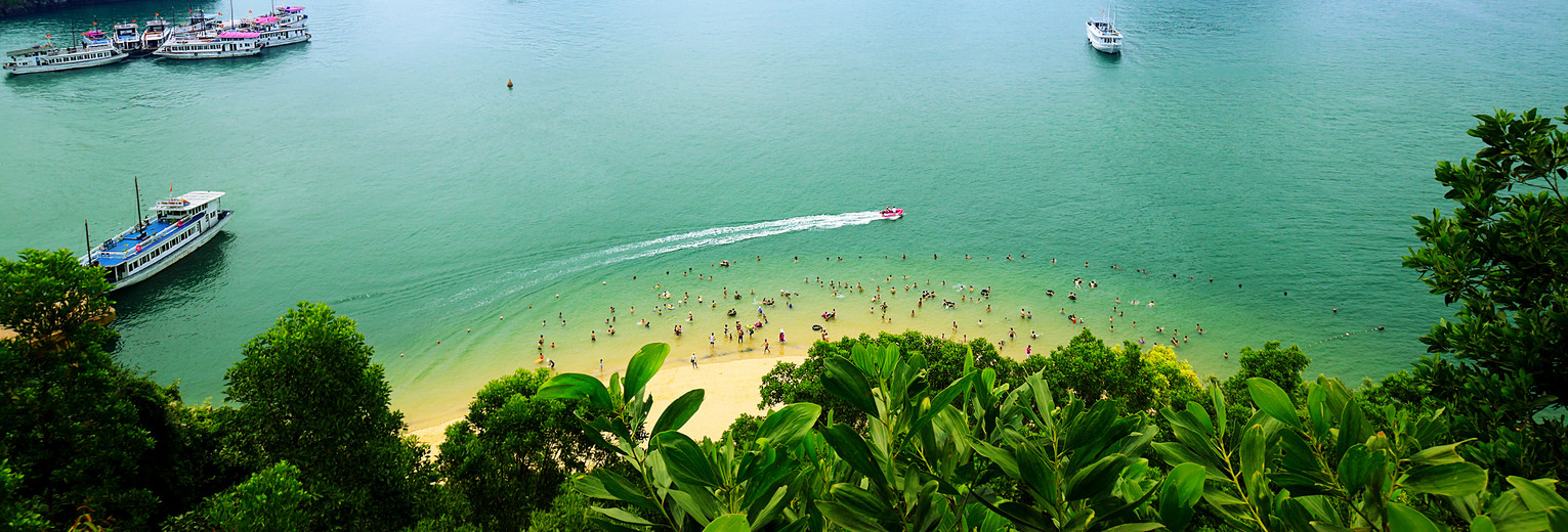 Ontspan op een strandje met zicht op de karstgebergten van Halong Bay, Vietnam Ontspan op een strandje met zicht op de karstgebergten van Halong Bay, Vietnam