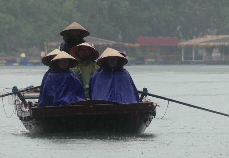 Varen met een kleinere boot lang de fishfarms, Halong Bay, Vietnam