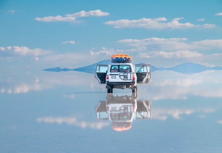 Een auto op de zoutvlaktes van Uyuni in Bolivia