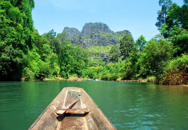 per bootje varen over de rivier bij Hinboun, Laos