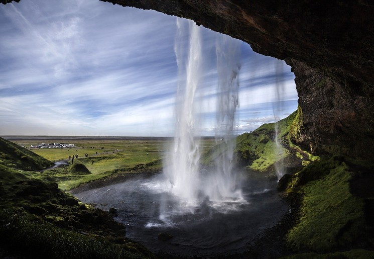 Achter de waterval Seljalandfoss lopen