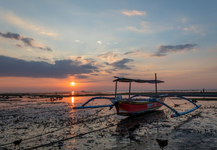Zonsondergangen bij de boten op de stranden van Bali