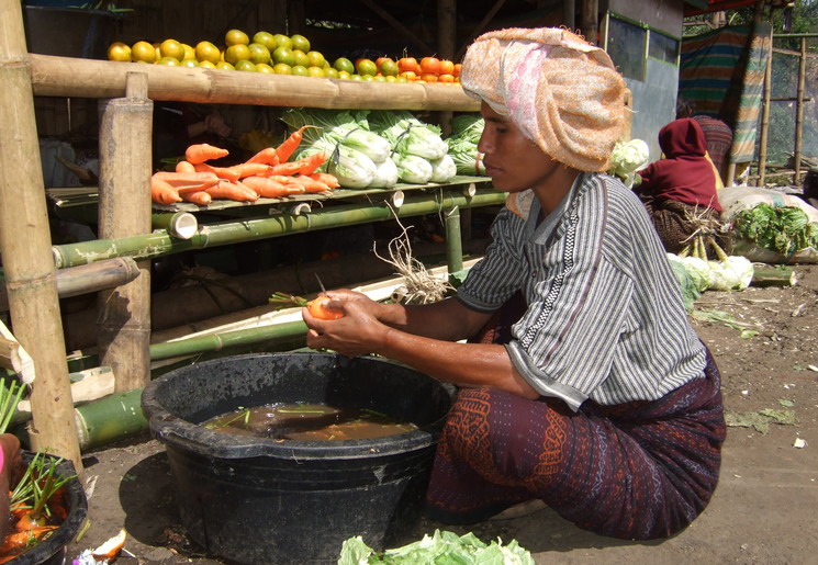 Marktvrouw bereid iets lekker voor in Ruteng