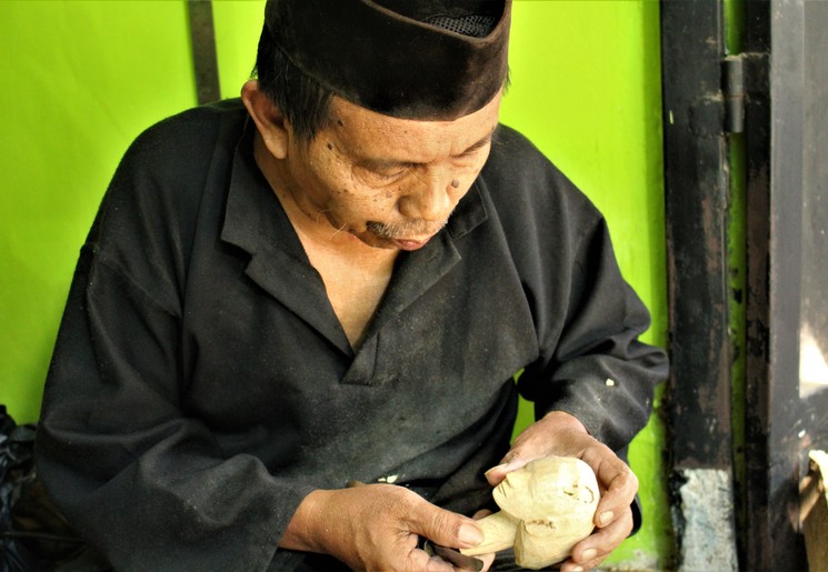 Een local werkt aan een Wayong-pop in Bogor op Java
