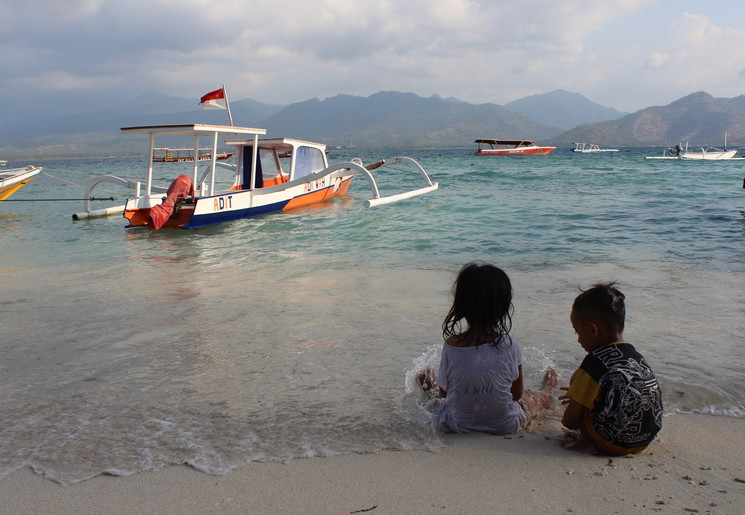 Kindjes spelen aan het strand bij Gili Air in Indonesie.