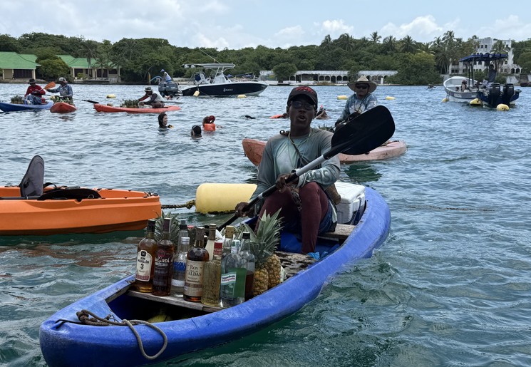 Local die op zijn bootje drankjes maakt, Islas del Rosario Colombia