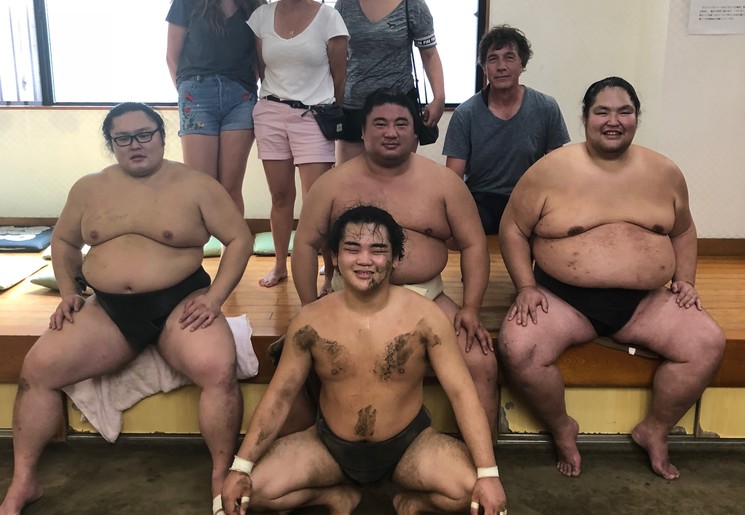 Klanten op de foto met sumo worstelaars in Tokyo