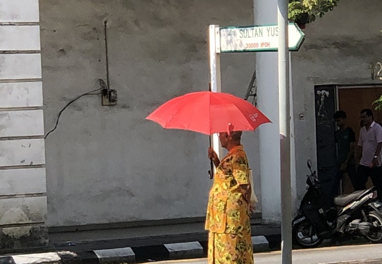 Vrouw met paraplu in Ipoh, Maleisë Vrouw met paraplu in Ipoh, Maleisë