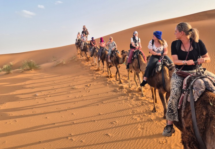 Op de rug van een dromedaris door de woestijn