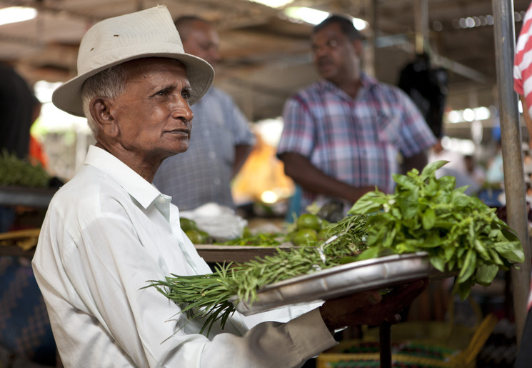 Een local koopt zijn ingrediënten op de markt in Mauritius