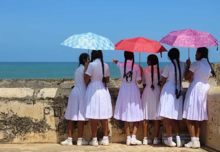 Schoolmeisjes kijken uit bij Fort uit over zee bij Galle, Sri Lanka