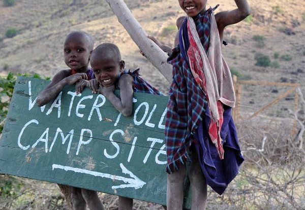 Tanzaniaanse kinderen verkopen water langs de weg