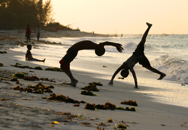 Kinderen genieten van het spelen op het strand op Zanzibar