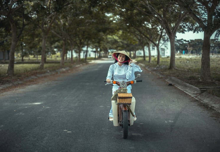 Een lokale dame op de scooter in Hue, Vietnam