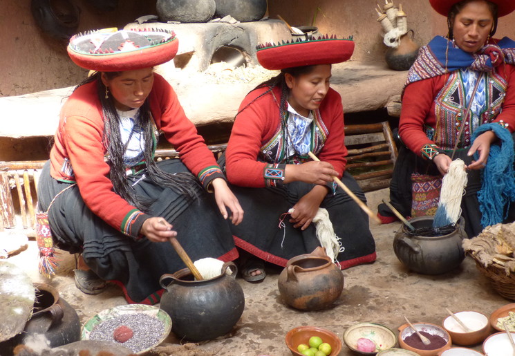 Traditioneel geklede vrouwen kleuren het geweefde wol in Maras, Peru