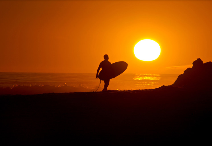 Surfen bij de ondergaande zon