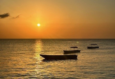 Bekijk de ondergaande zon vanaf het strand in Zanzibar