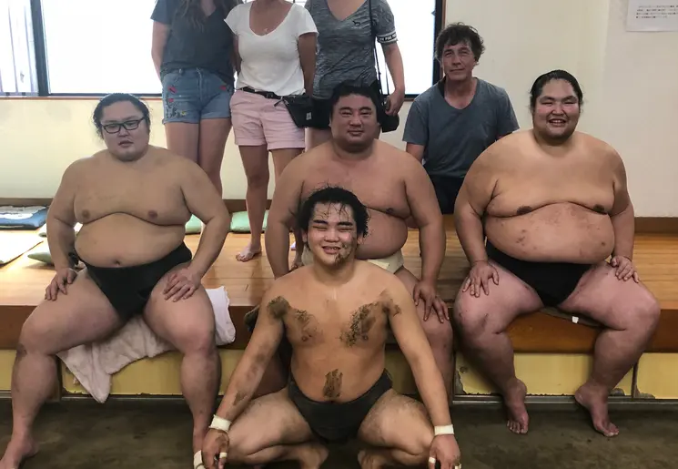 Klanten op de foto met sumo worstelaars in Tokyo
