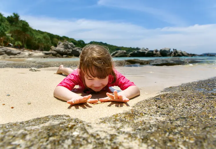 Kind op het strand met zand te spelen