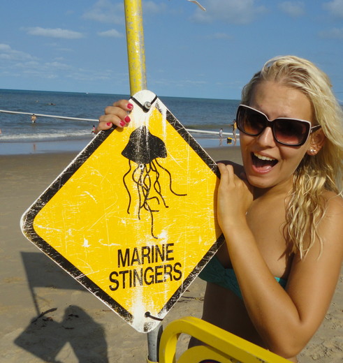 Van Verre medewerker Lisanne bij waarschuwingsbord kwallen op het strand, Australië