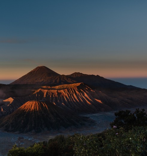 Langzaam wordt de Bromo-vulkaan verlicht tijdens de zonsopkomst, Java