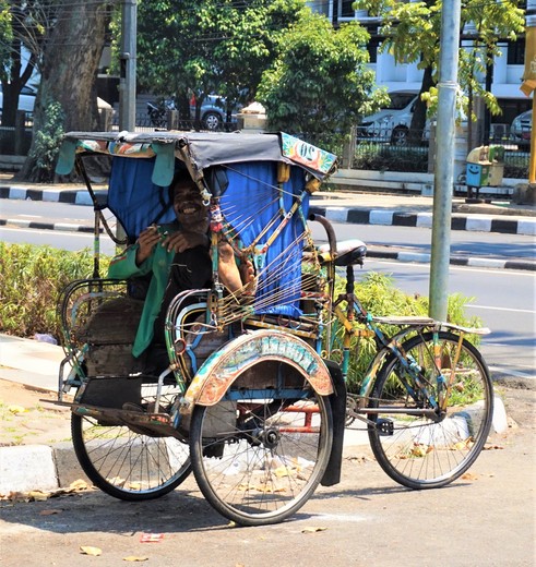 Een gekleurde fietstaxi in Bandung, Java