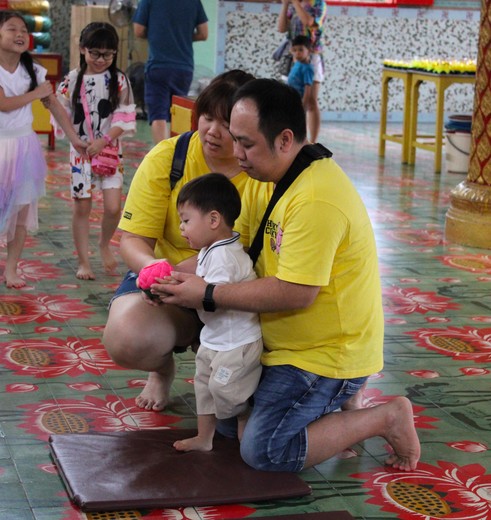 Vader, moeder en kind offeren bij de tempel op Penang