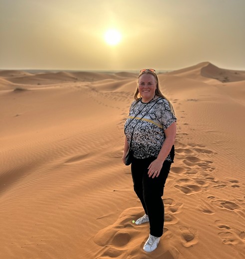Collega Chantal bij zonsondergang in de Sahara van Marokko
