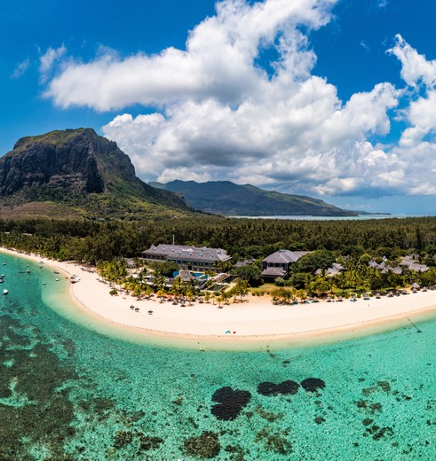 Een heldere zee met wit zandstrand en de berg Le Morne