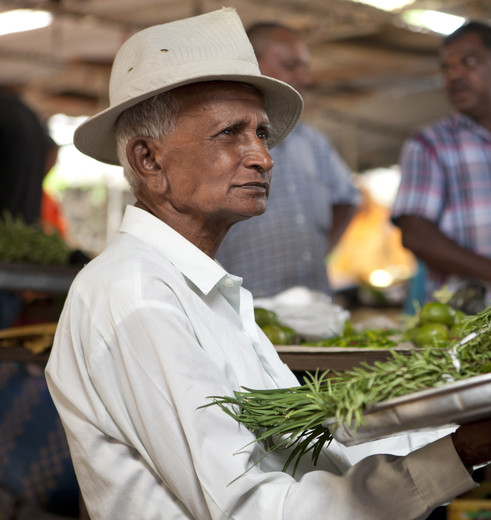 Een local koopt zijn ingrediënten op de markt in Mauritius