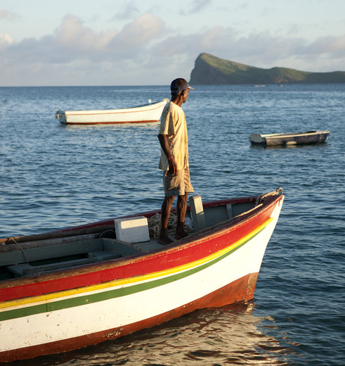 Een visser geniet van het uitzicht van Pointe aux Canonniers, Mauritius