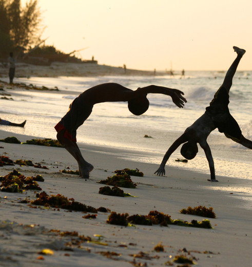 Kinderen genieten van het spelen op het strand op Zanzibar