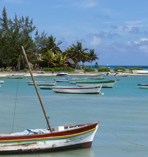 Een vissersbootje in het helderblauwe water in Mauritius