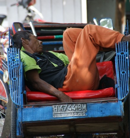 Locale bewonder ligt te slapen in zijn fietstaxi