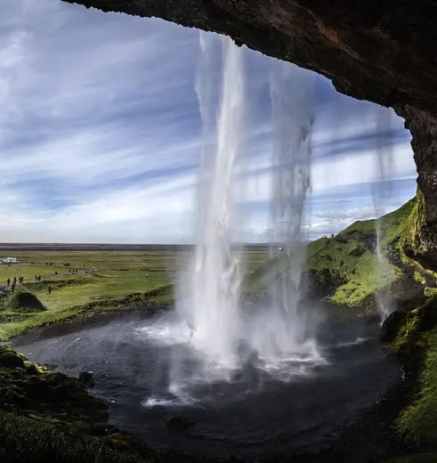 Achter de waterval Seljalandfoss lopen