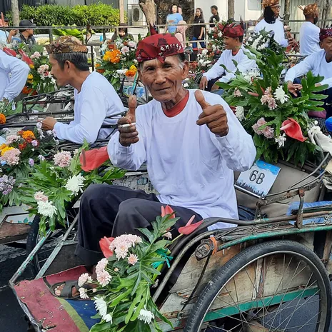 Locals op een gekleurde fiets in Surabaya, Java