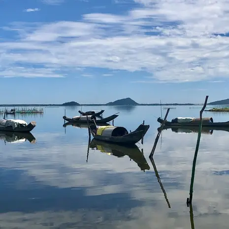 Onderweg van Hue naar Hoi An liggen er boten in de grote rivier
